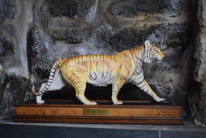 ceramic tiger stood upon wooden plinth