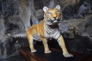 ceramic tiger stood upon wooden plinth